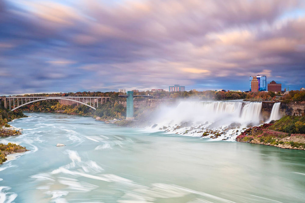American Falls and Rainbow Bridge crossing the Niagara River, Niagara Falls - Cheapest Time